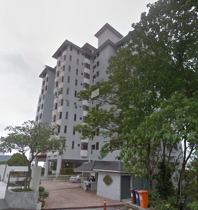 Desa Bangsar Ria: A tall residential apartment tower viewed from the street, with entrance driveway, trees, and trash bins in front