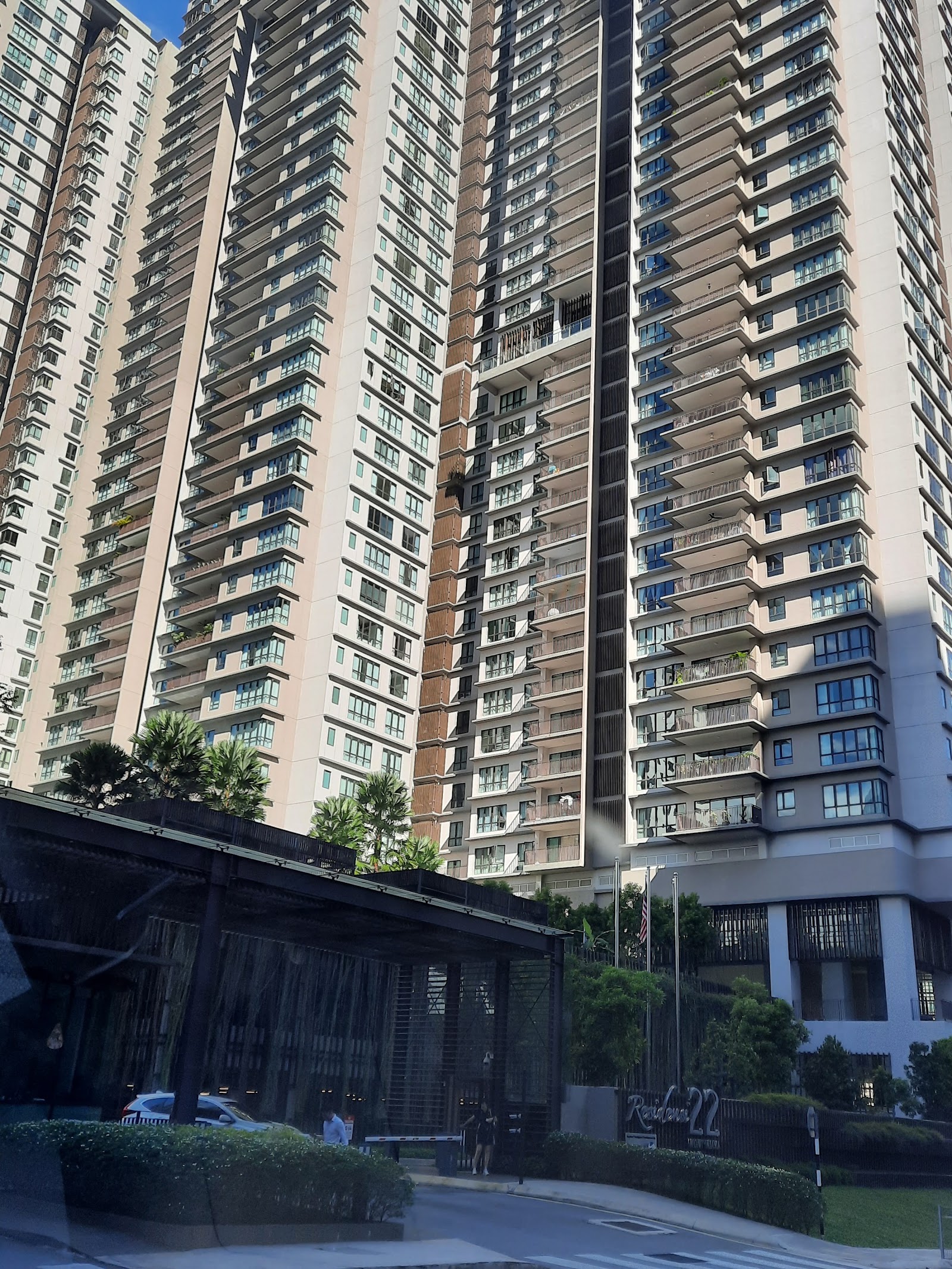 Residensi 22: High-rise residential towers with balconies, entrance driveway and covered drop-off area in front