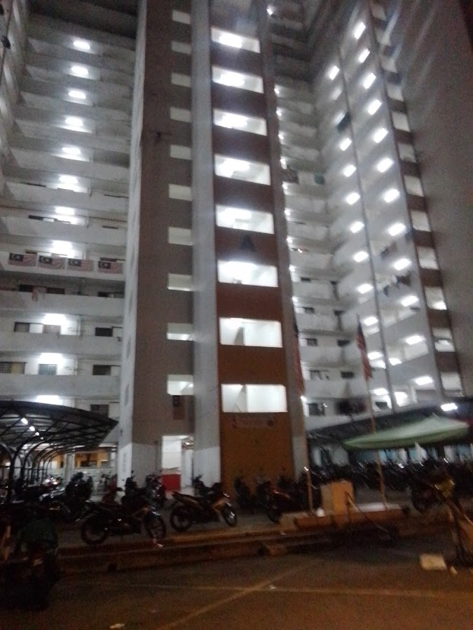 PPR Pantai Ria: the block at night, its corridors lit and motorcycles parked below