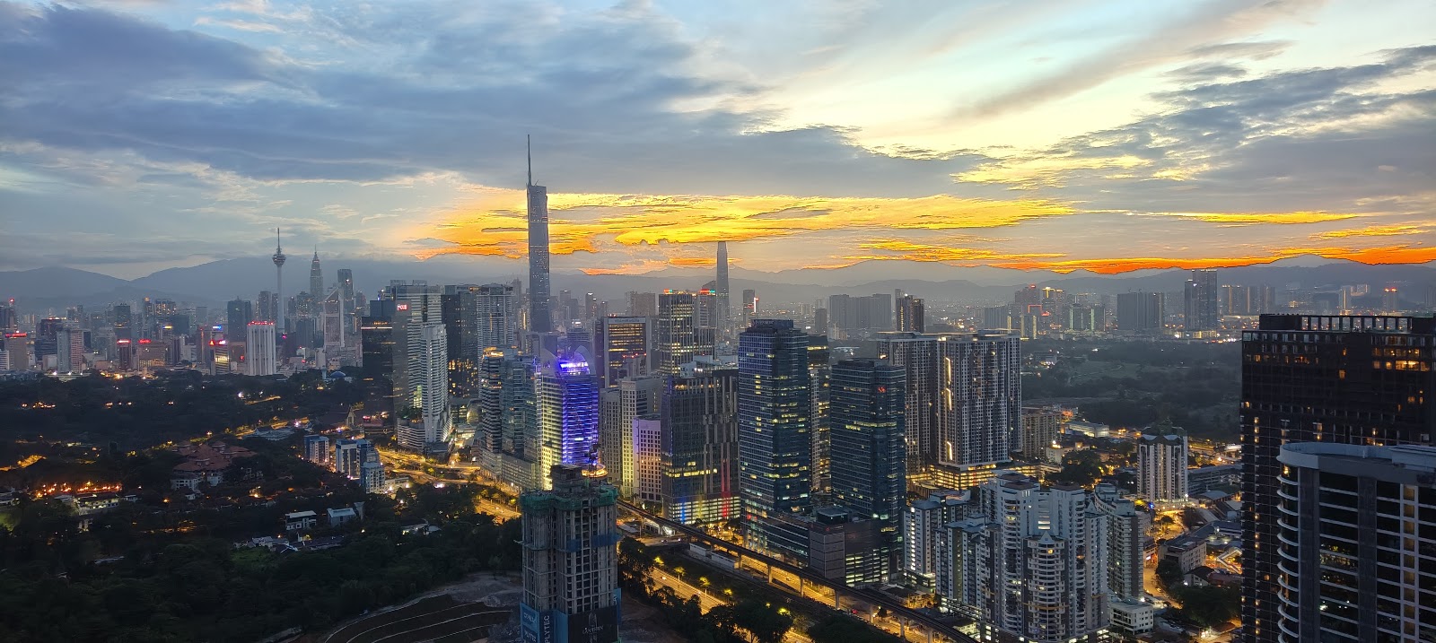 Bangsar Hill Park: Aerial night view of Kuala Lumpur city skyline with skyscrapers and KL Tower at sunset