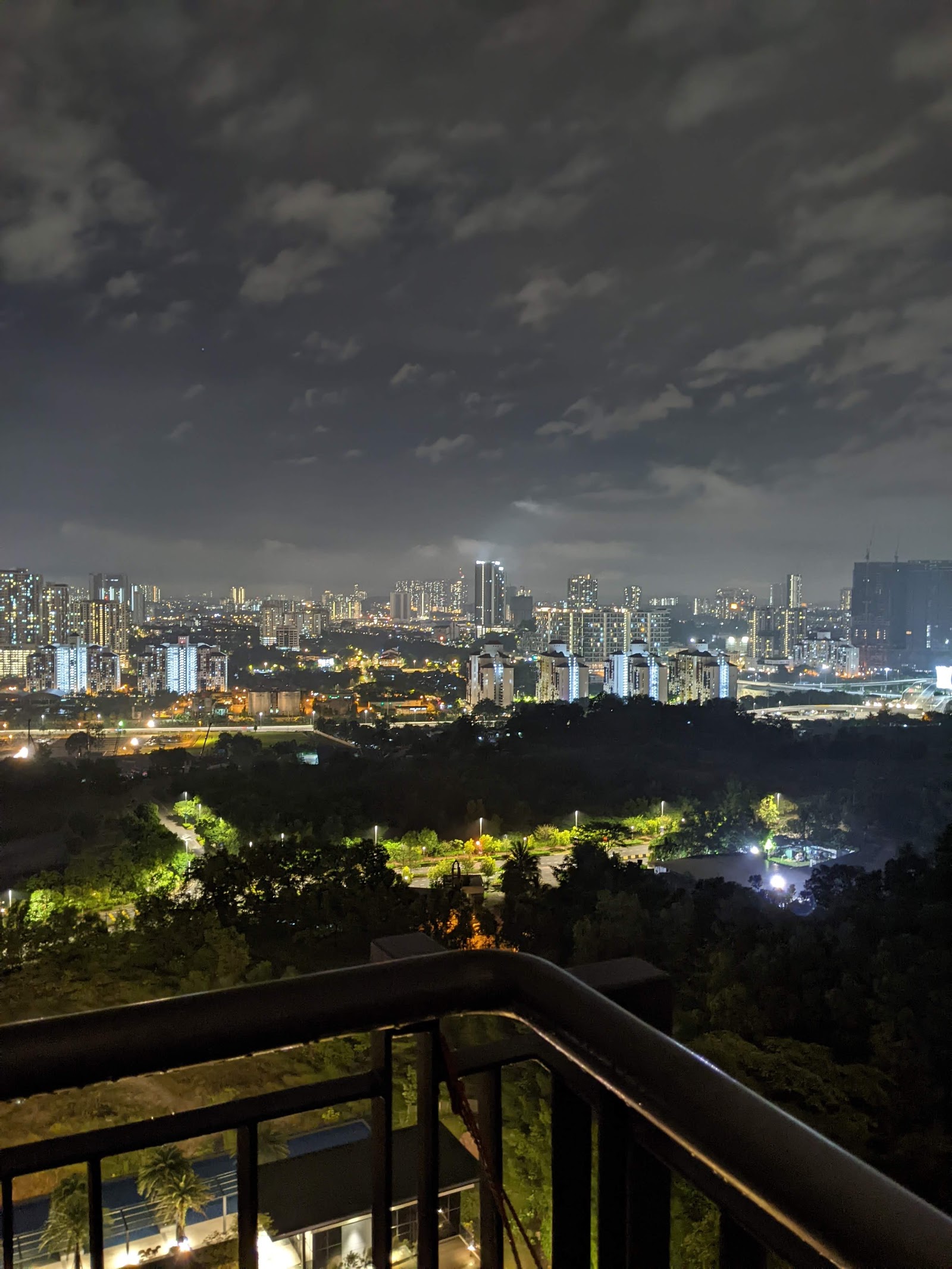 Inwood Residences: Nighttime cityscape view from a high-rise balcony overlooking a park and city skyline with illuminated buildings