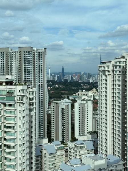 Tiffani Kiara: High-rise condominium towers with distant city skyline and hills behind