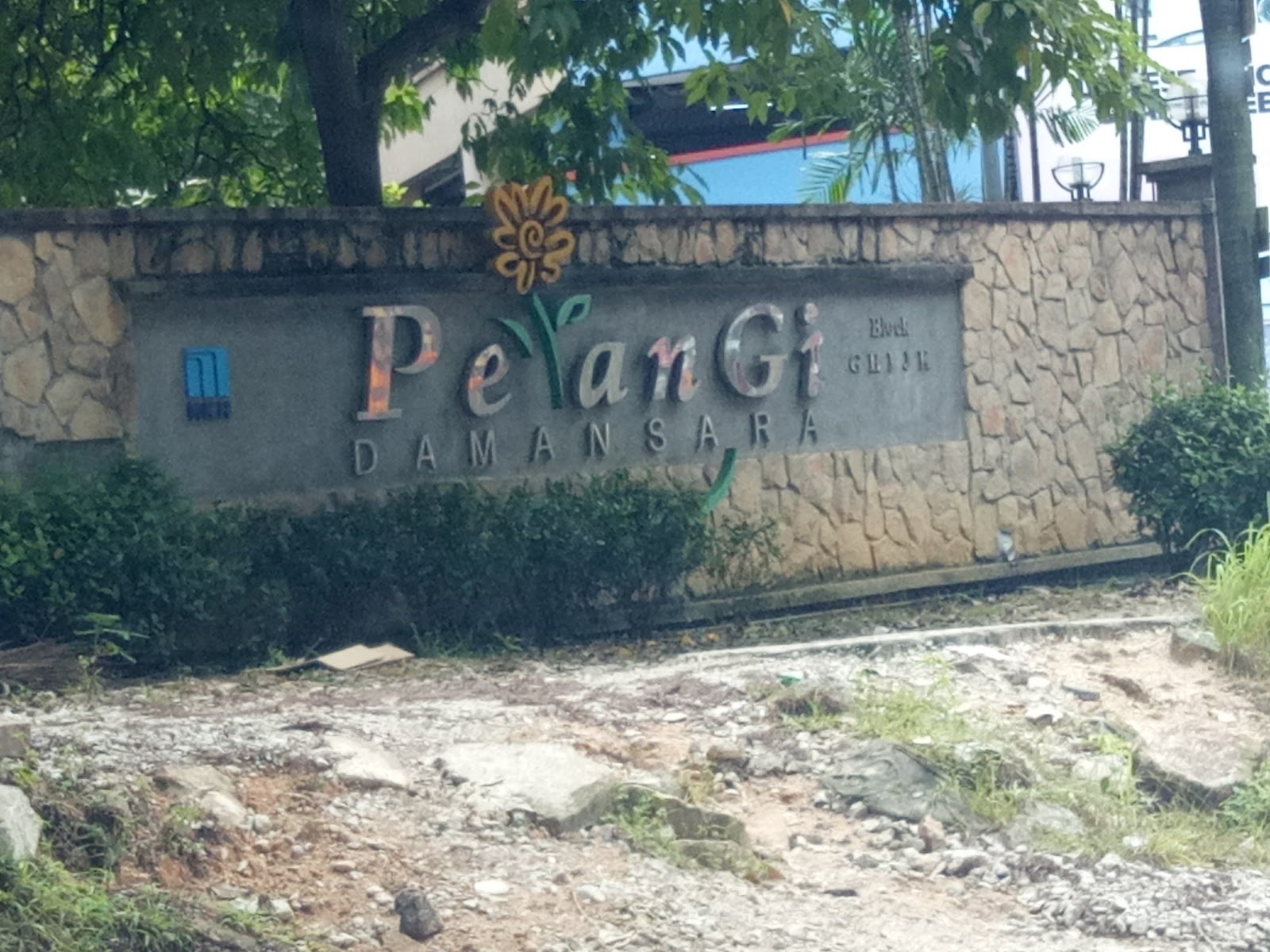 Pelangi Damansara: Entrance sign wall for Pelangi Damansara development with stone cladding and decorative flower motif