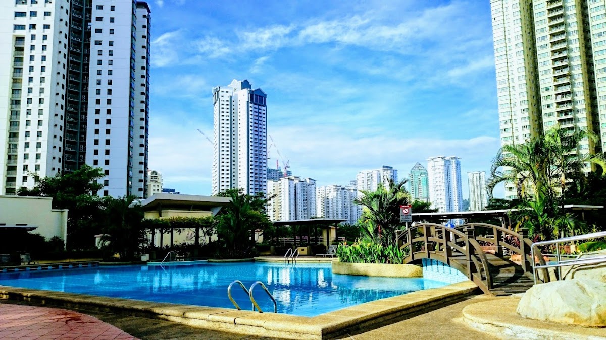 Mont Kiara Bayu: the pool and its timber footbridge, towers beyond