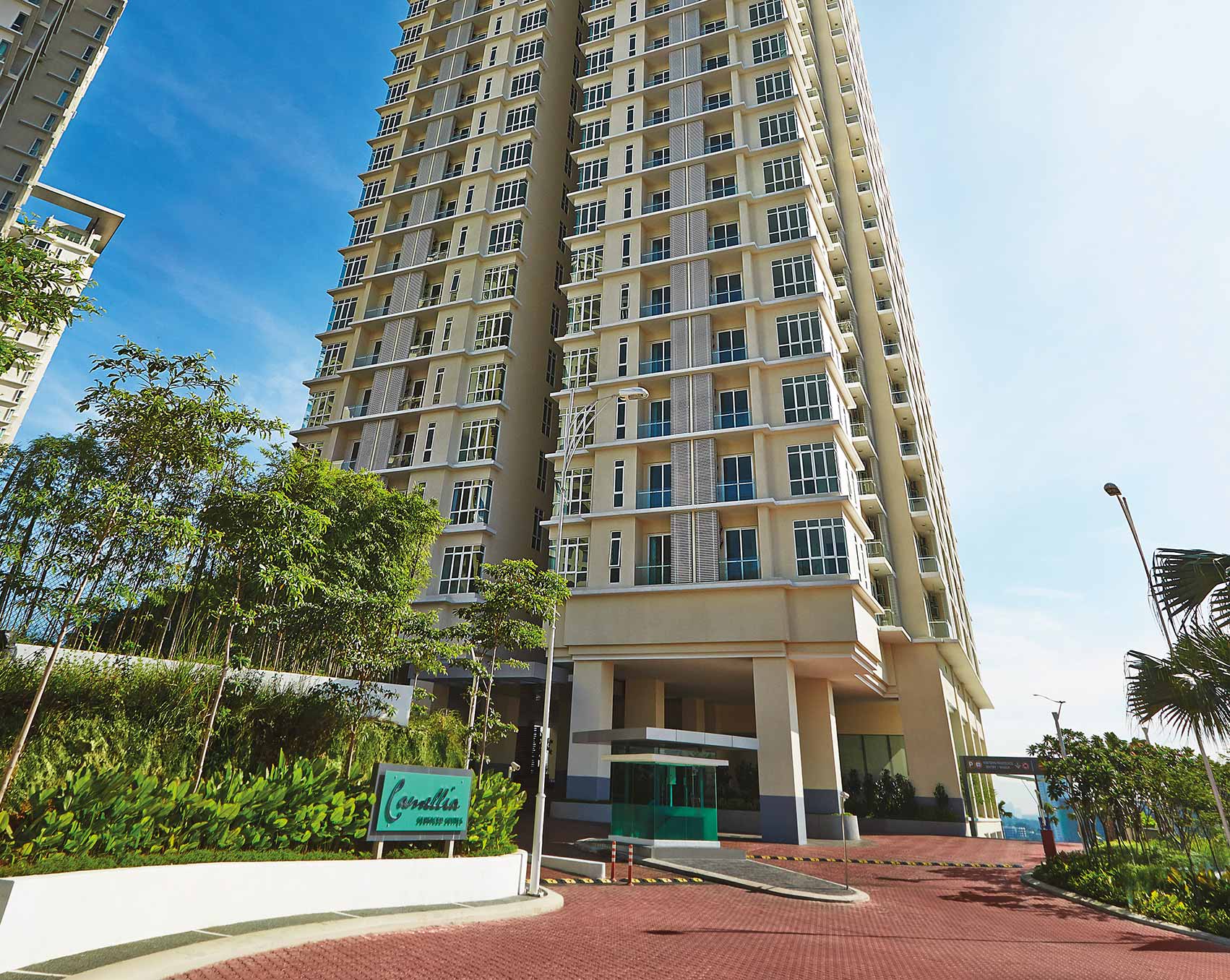 Camellia Serviced Suites: the tower above its landscaped entrance and Camellia sign