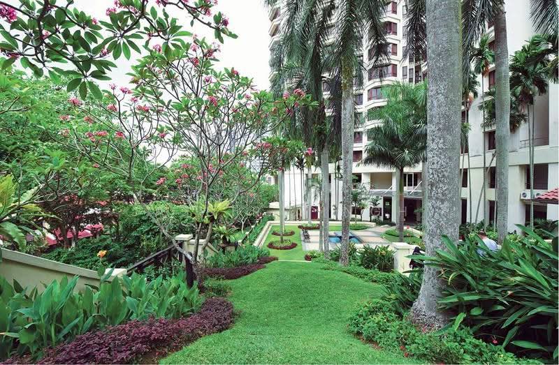 Sri Penaga: Lawn and planted garden with palm trees beside an apartment block