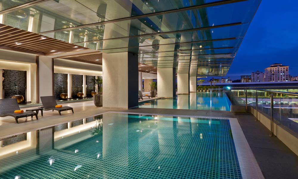 VE Hotel & Residence: the pool under its glass canopy at dusk