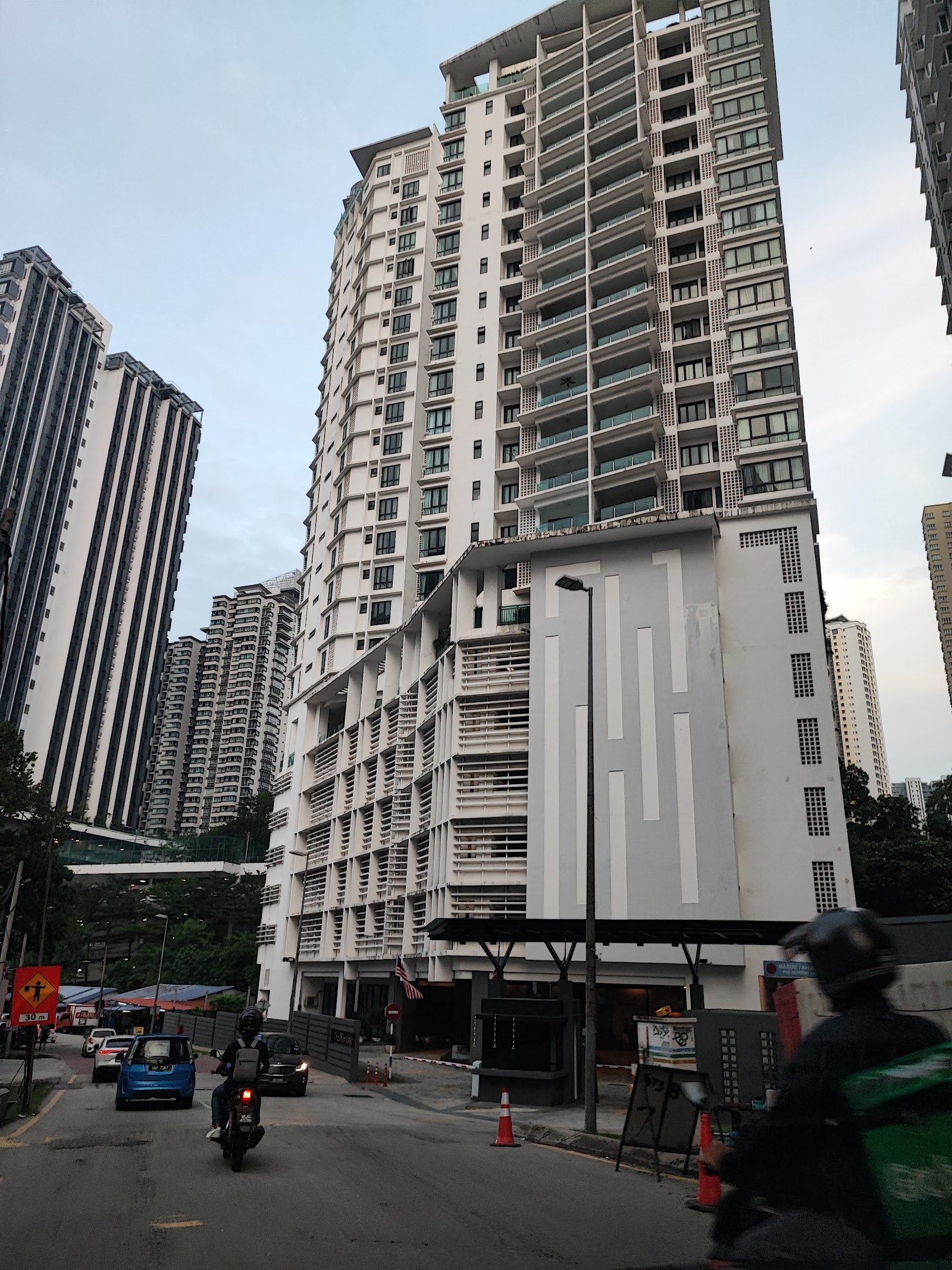 Richmond: Street view of high-rise residential towers with people on a motorcycle and cars passing by