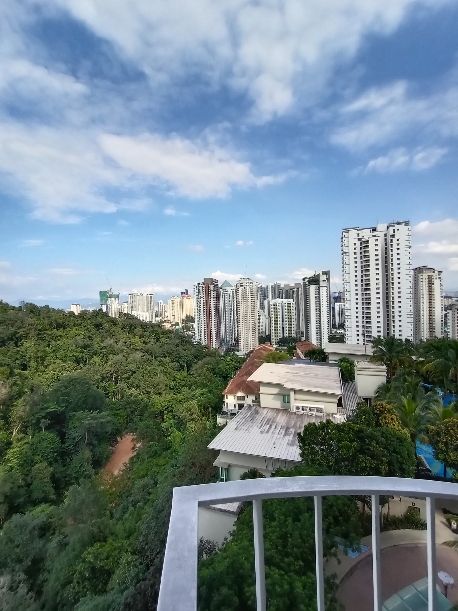 Kiaramas Ayuria: View of city skyline with high-rise towers and lush greenery, seen from a residential balcony railing