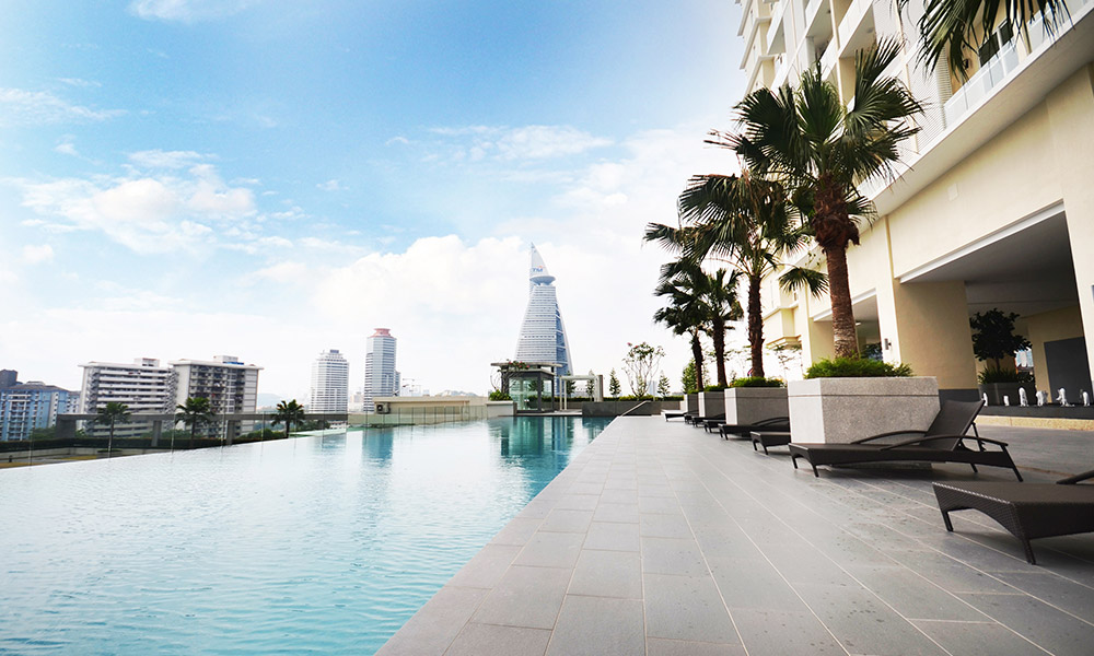 Camellia Serviced Suites: the pool deck with palms, the city beyond