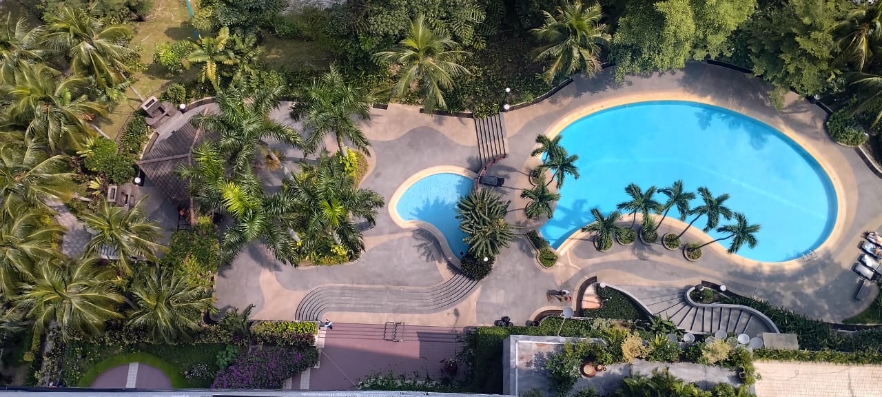 Bangsar Puteri: Aerial view of a resort-style swimming pool area with palm trees and landscaped walkways