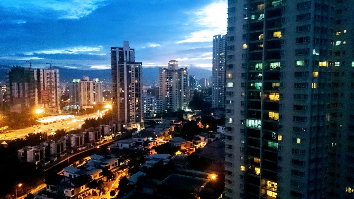 Mont Kiara Bayu: the city at dusk from a high floor, a tower alongside