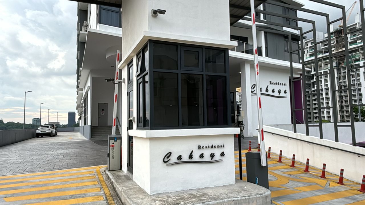 Residensi Cahaya: Entrance area of Residensi Cahaya development with signage, security guardhouse, parking barrier and driveway