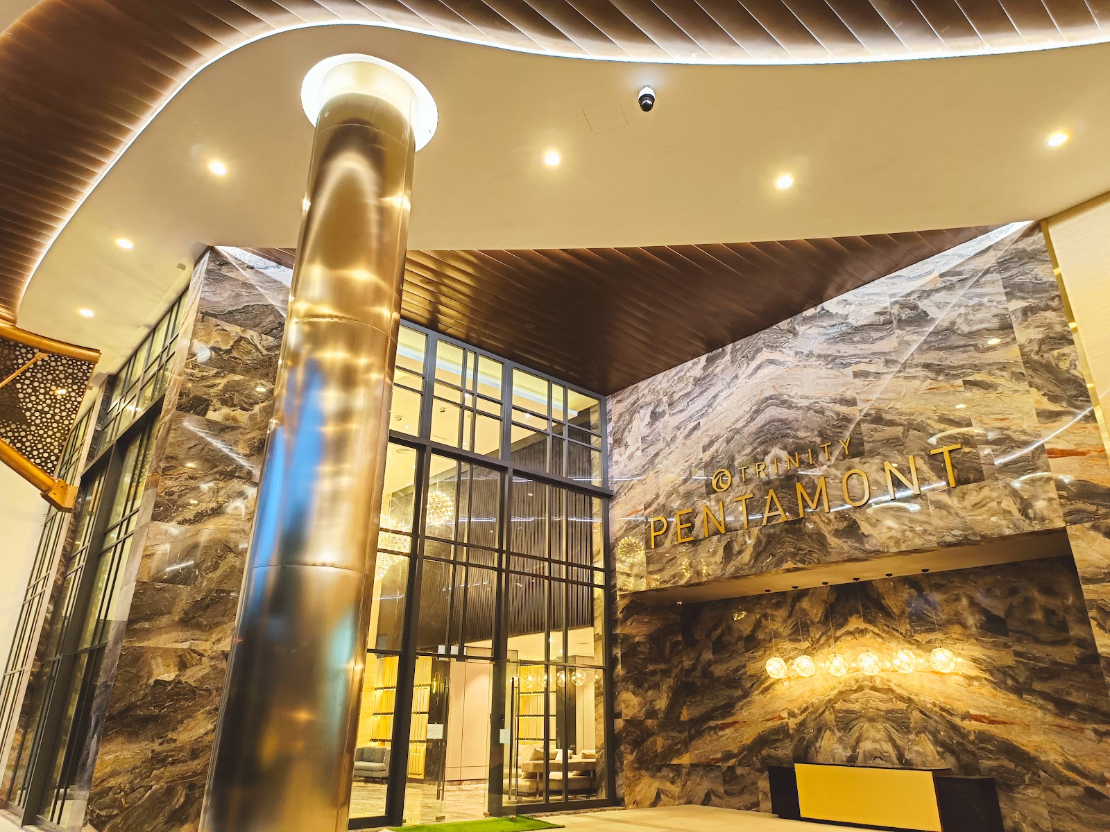Trinity Pentamont: Entrance lobby facade of Trinity Pentamont with marble walls, gold column, and glass doors