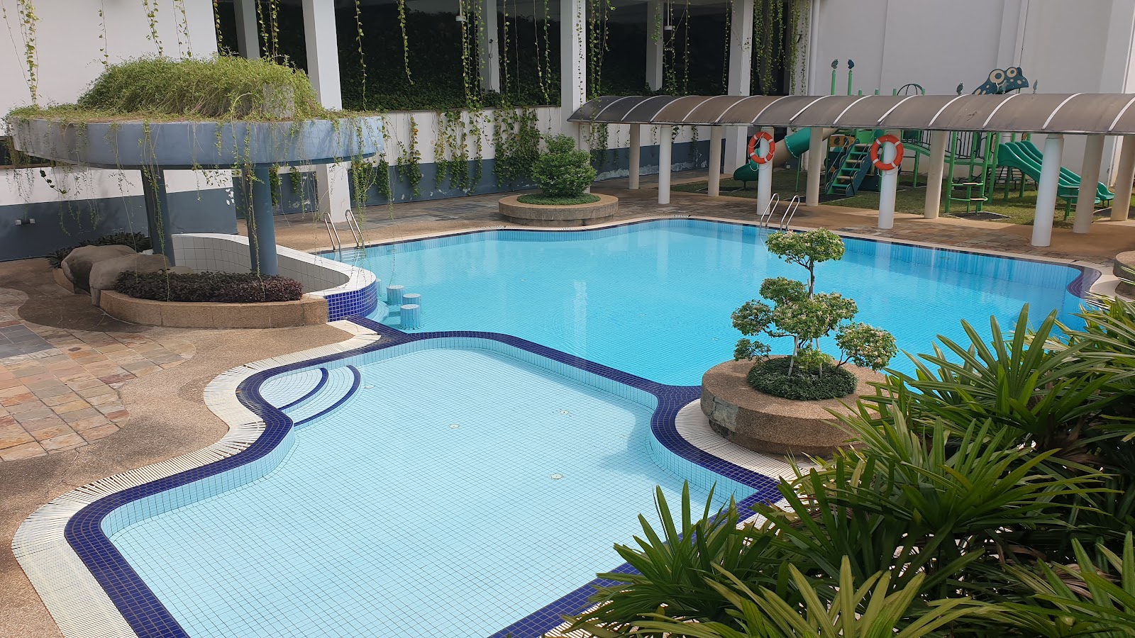 Casa Vista: Outdoor swimming pool with decorative garden feature, kiddie pool, and playground area in a residential development