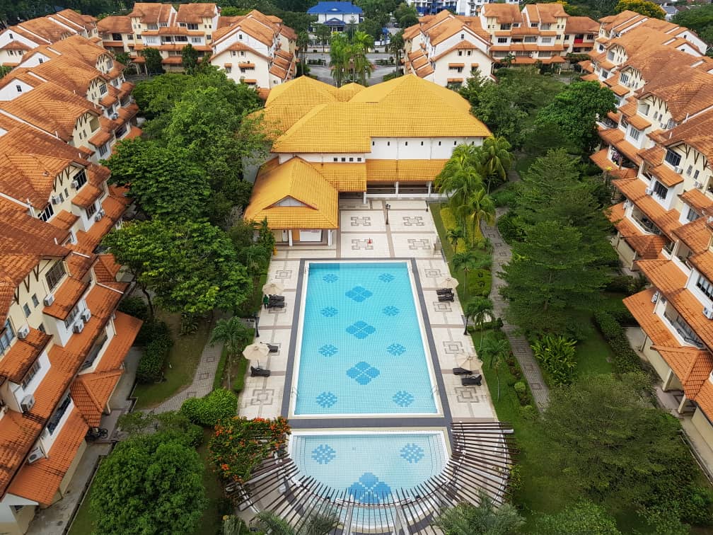 Villa Flora: the pool and clubhouse among the red-roofed blocks, from the air