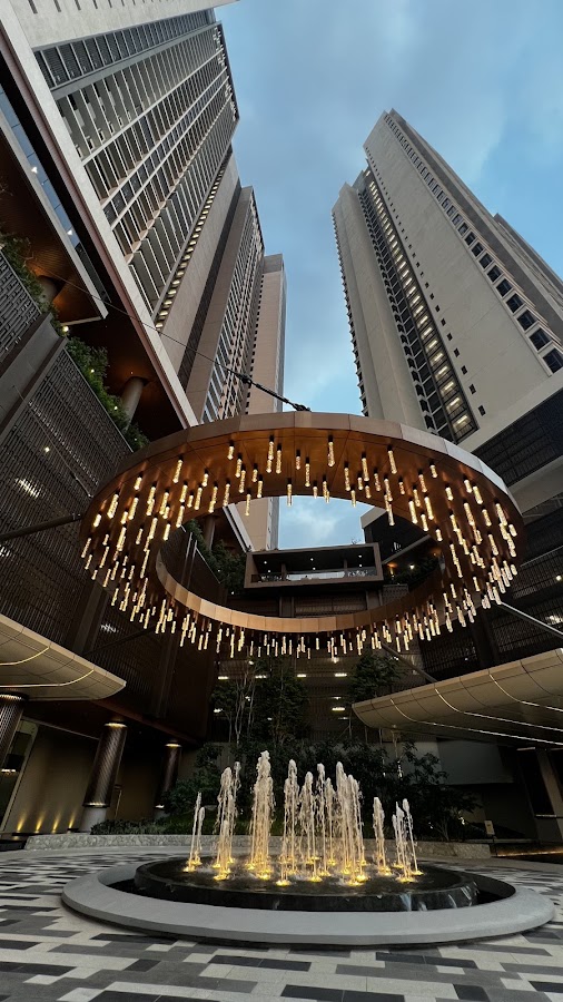 Jendela Residences: the lit ring sculpture and fountain between the towers