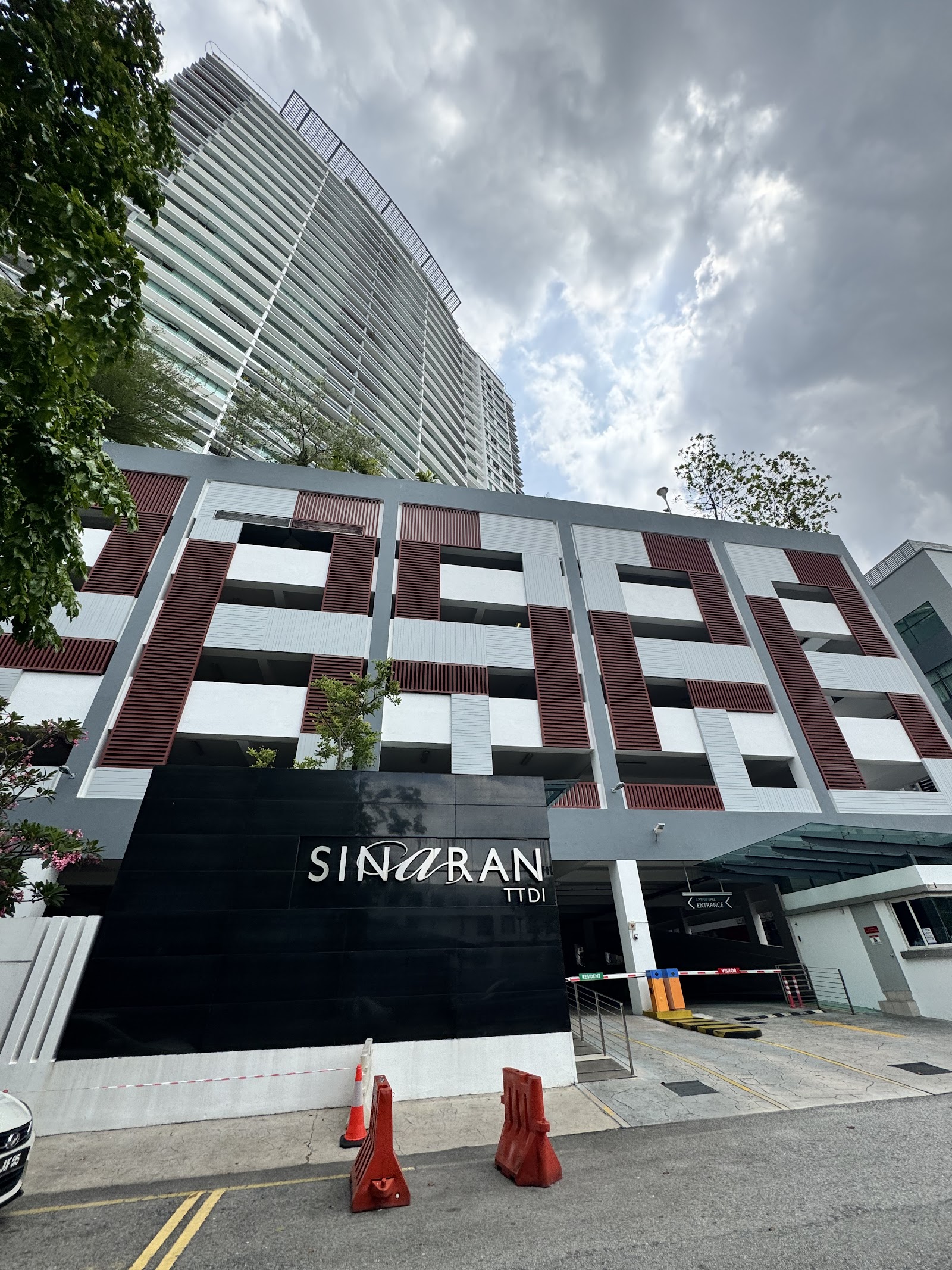 Sinaran TTDI: Street-level view of the Sinaran TTDI residential building facade with entrance sign, showing high-rise tower behind