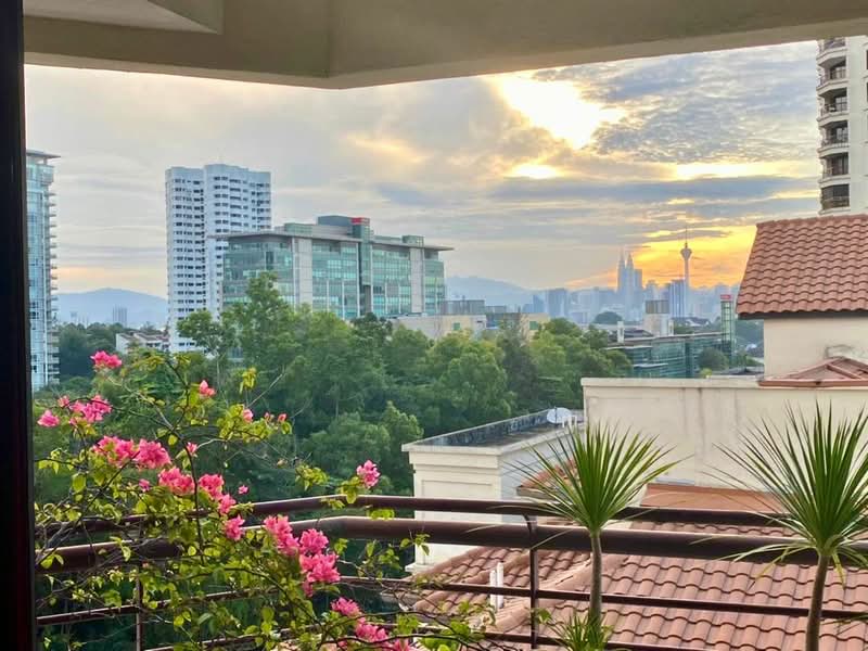 Sri Penaga: City skyline and treetops at sunset seen past a balcony rail