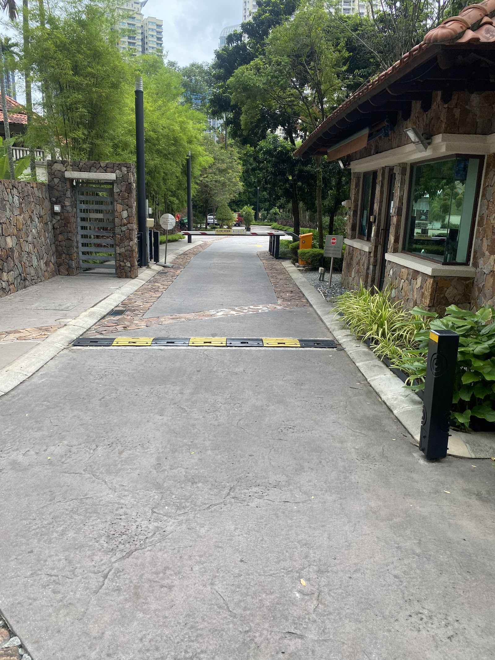 Mont Kiara Damai Resort Condominium: Guardhouse and entrance driveway with security barrier, speed bump, and stone-walled gate at a condominium entrance