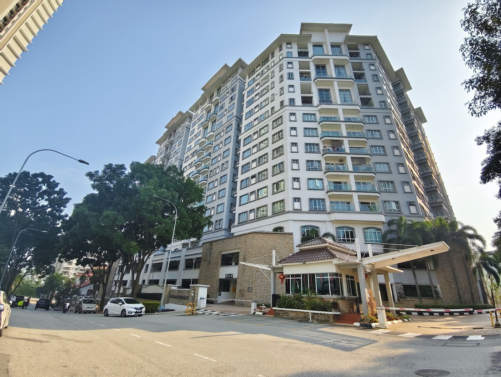 Hartamas Regency 2 Mont Kiara: High-rise residential tower with balconies, street view including trees and parked cars in front of the building entrance