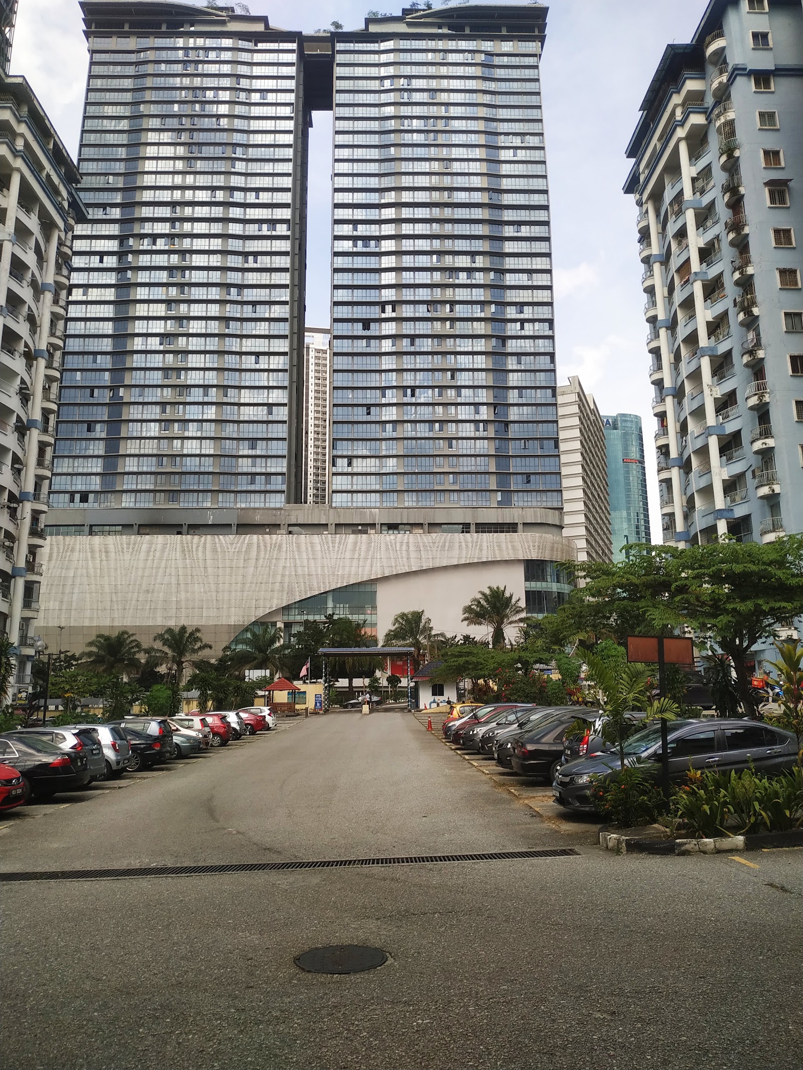 KL Gateway Residences: Exterior view of high-rise residential towers with a parking area in front and driveway leading to the entrance