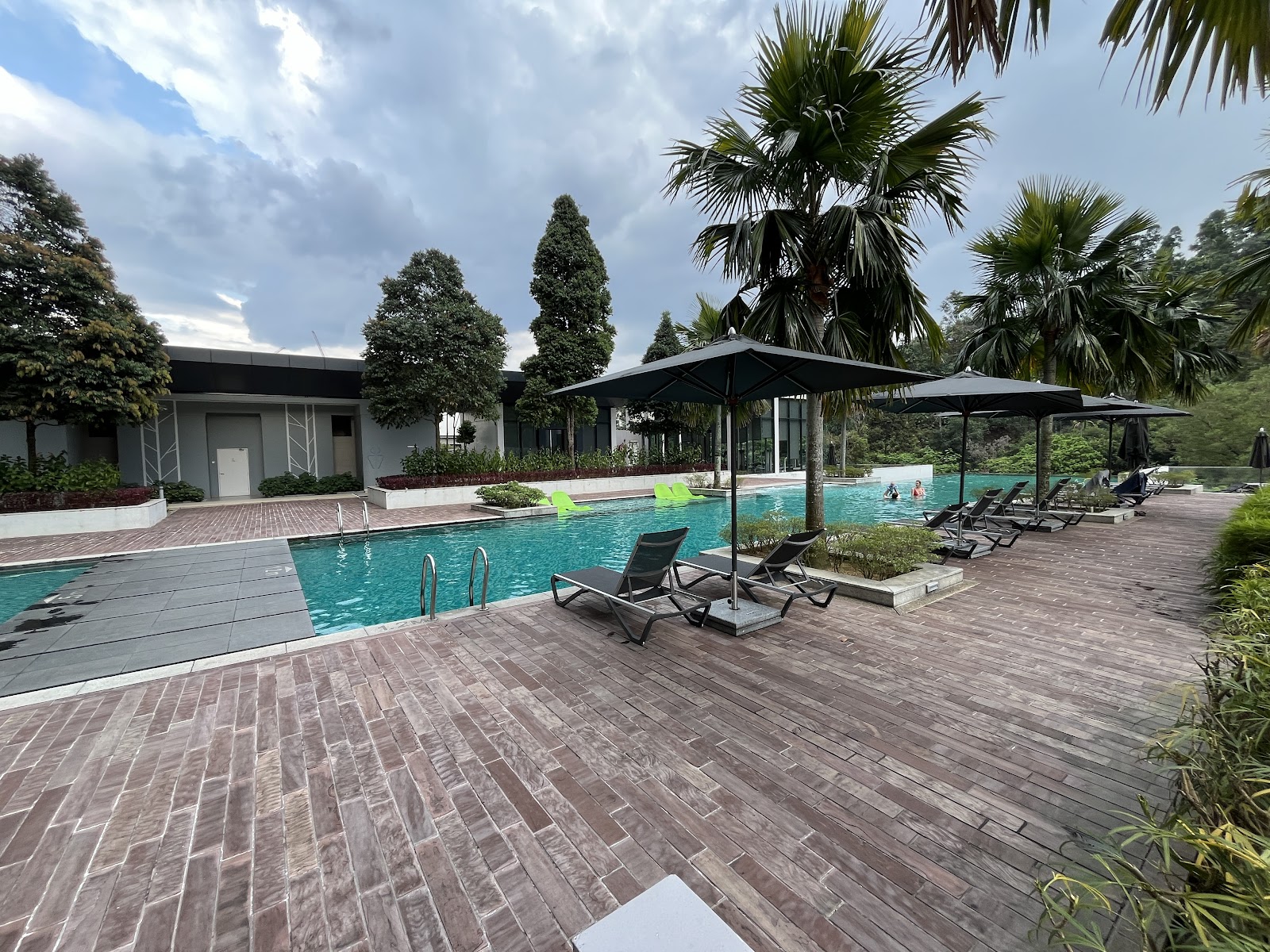 Inwood Residences: Outdoor swimming pool with sun loungers, umbrellas, and palm trees at a residential development