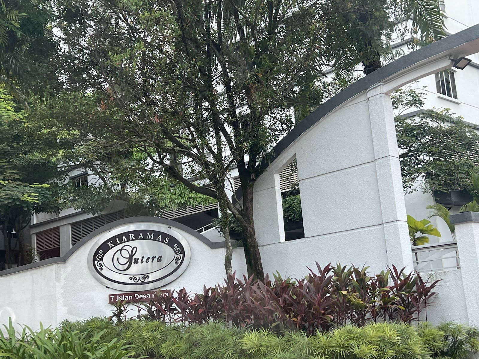 Kiaramas Sutera: Entrance wall sign for Kiaramas Sutera with trees and the building facade behind