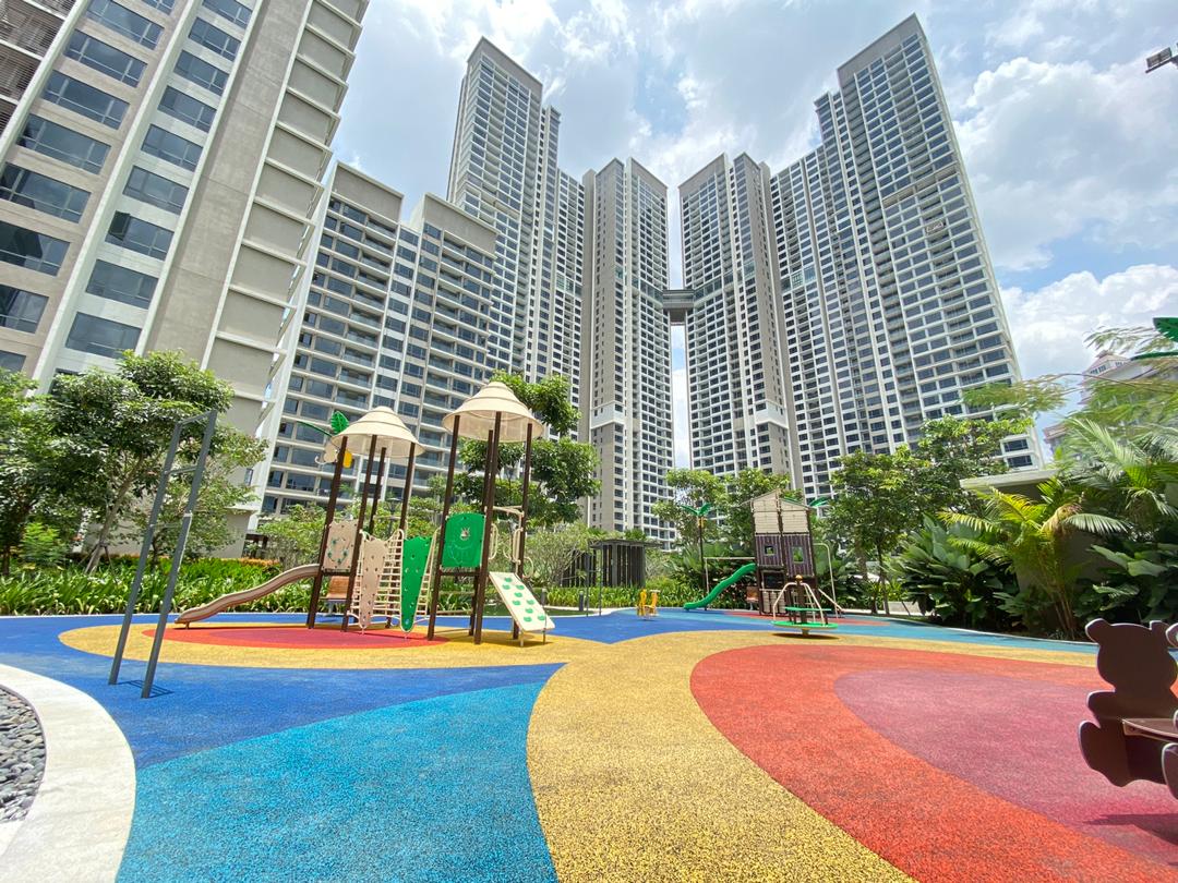 Agile Mont Kiara: A colorful playground with slides and climbing structures set on rubberized flooring, surrounded by tall residential towers