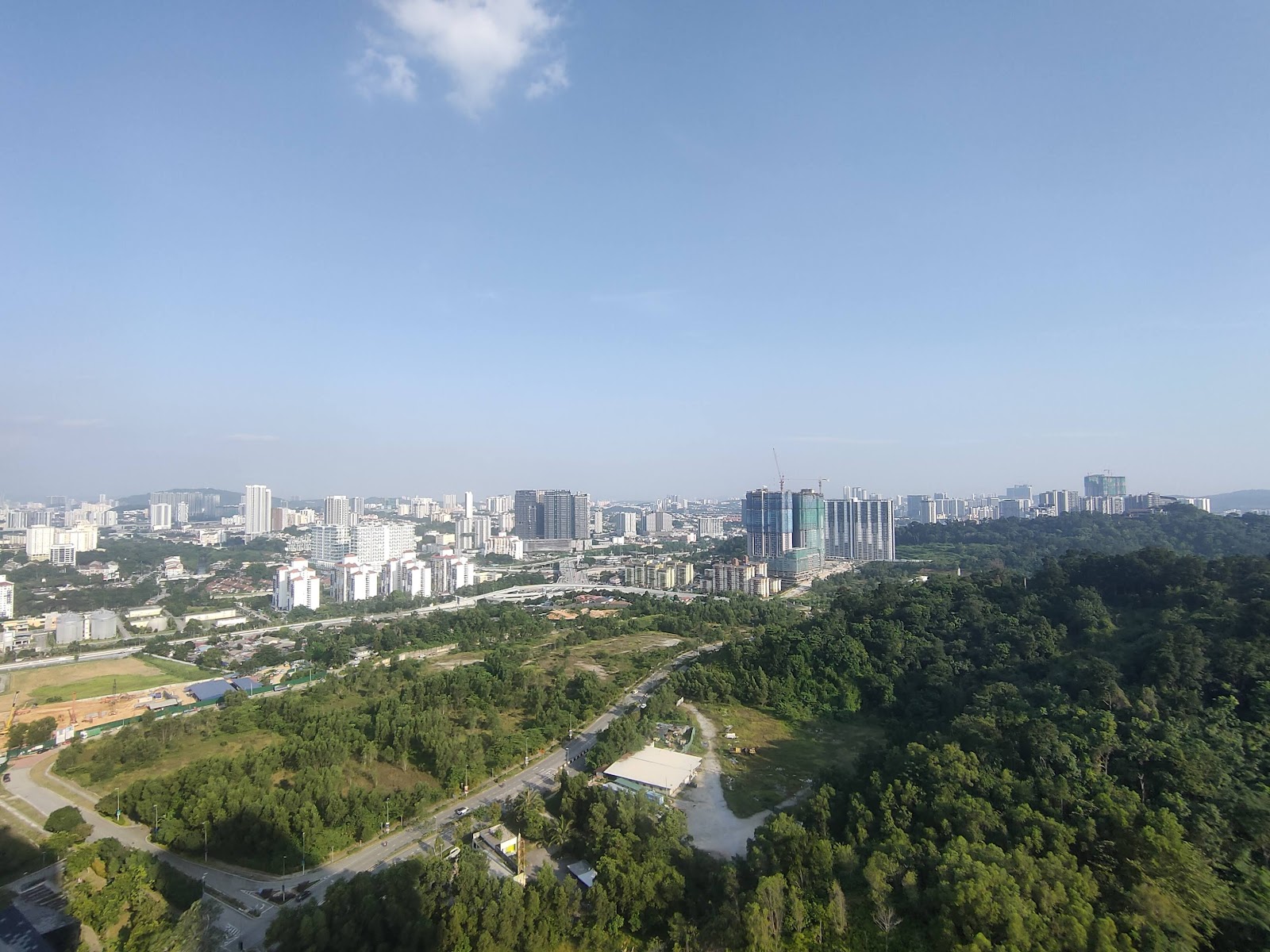 Secoya Residences @ Pantai Sentral Park: Aerial cityscape view from the development showing surrounding trees, roads, and city skyline with high-rise buildings under construction