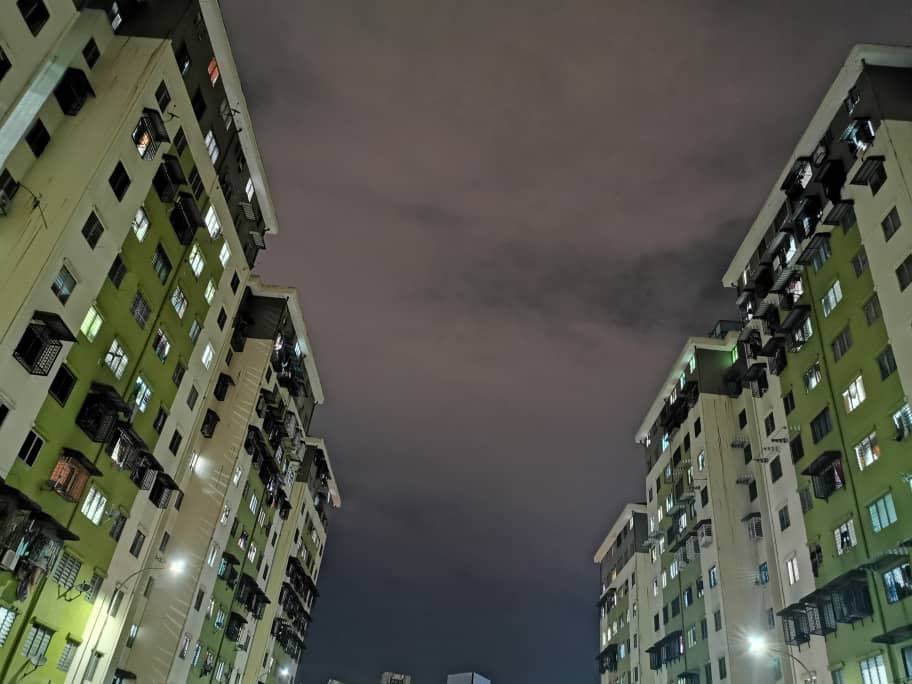 Pantai Indah Apartment: two blocks at night, looking up between them