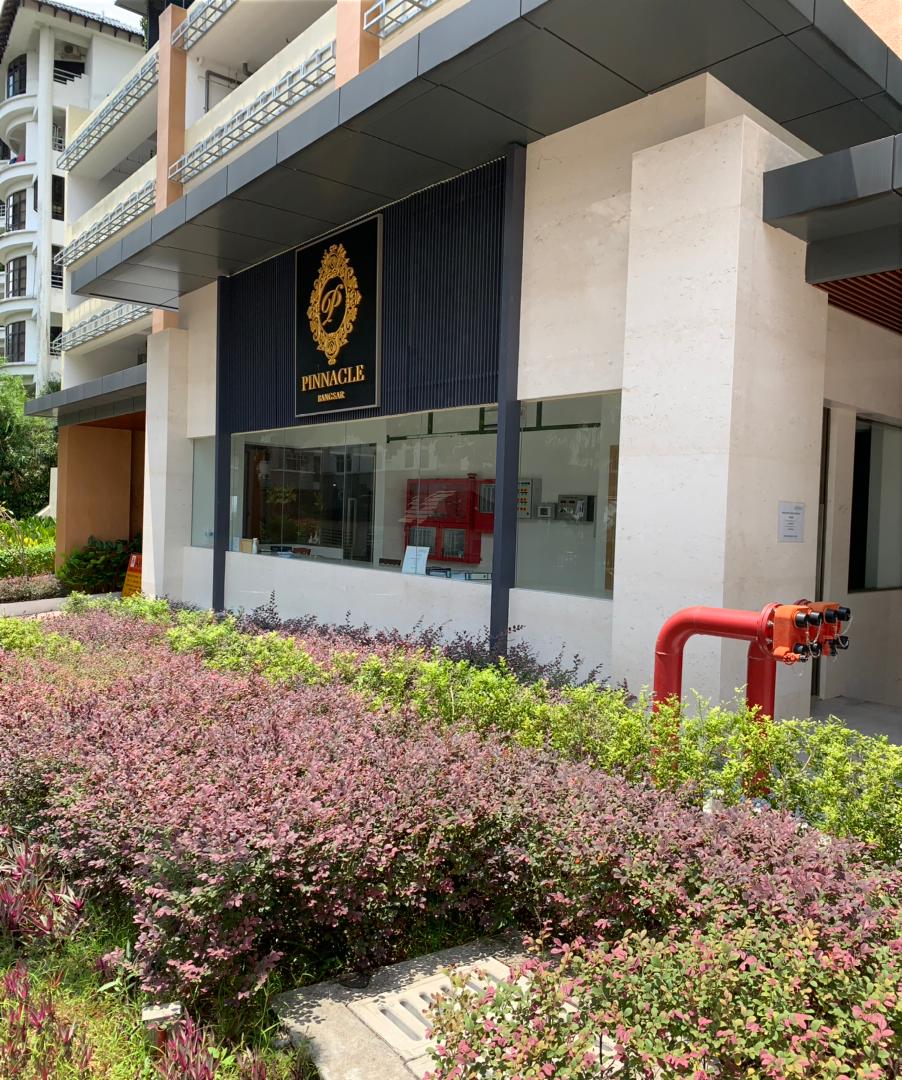 Pinnacle Bangsar: Entrance area of Pinnacle Bangsar building with a lobby/security counter window, signage, landscaping, and a fire hydrant standpipe