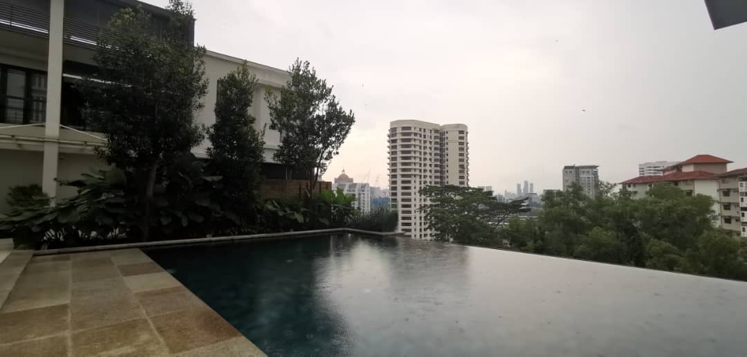Bangsar Peak: Infinity-edge rooftop swimming pool with a view of surrounding trees, city buildings and towers