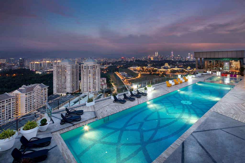 Dorsett Residences Sri Hartamas: the rooftop pool at dusk, the city skyline beyond