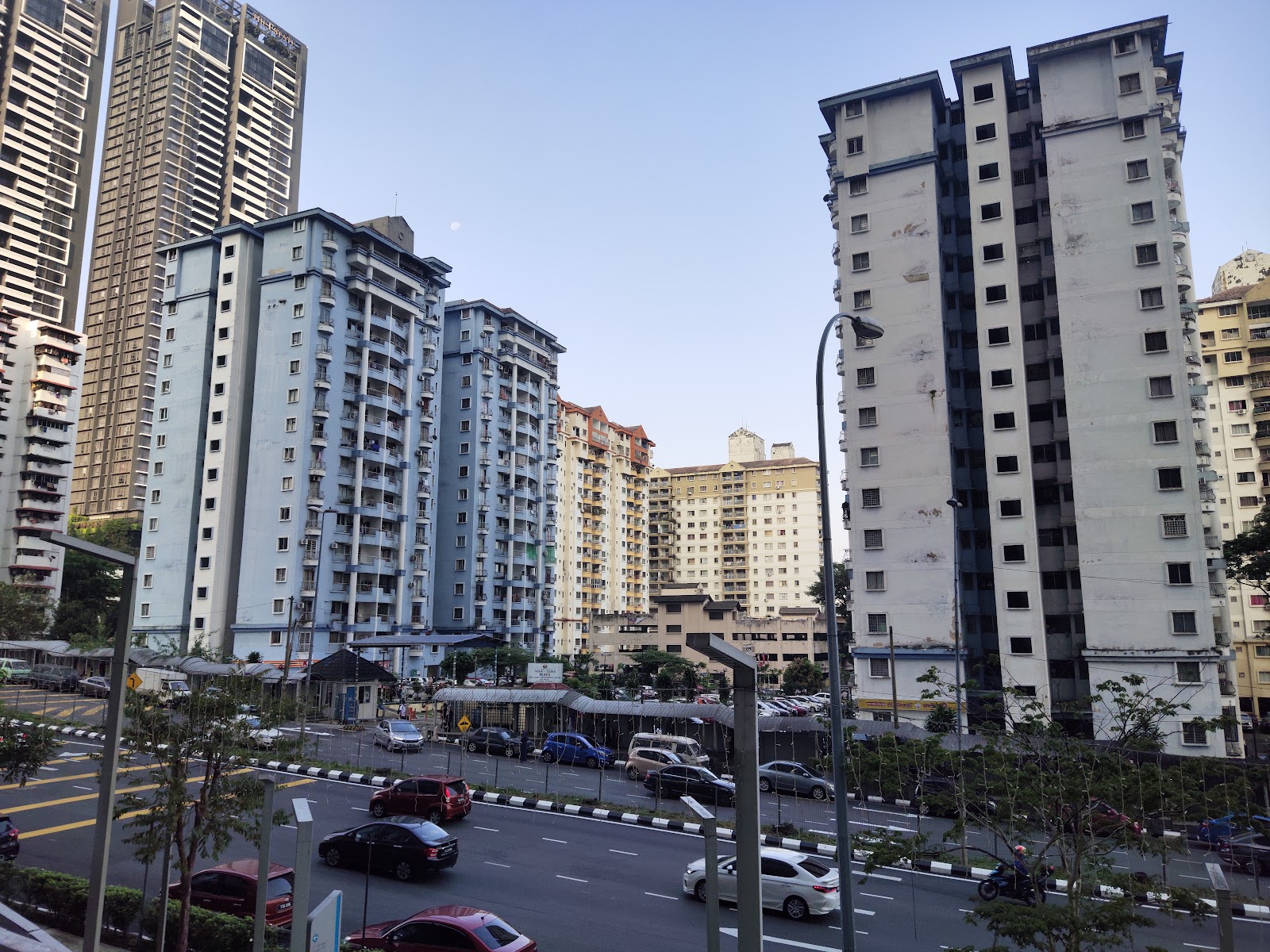 Vista Angkasa: Street view of high-rise residential towers with a busy road and traffic in the foreground