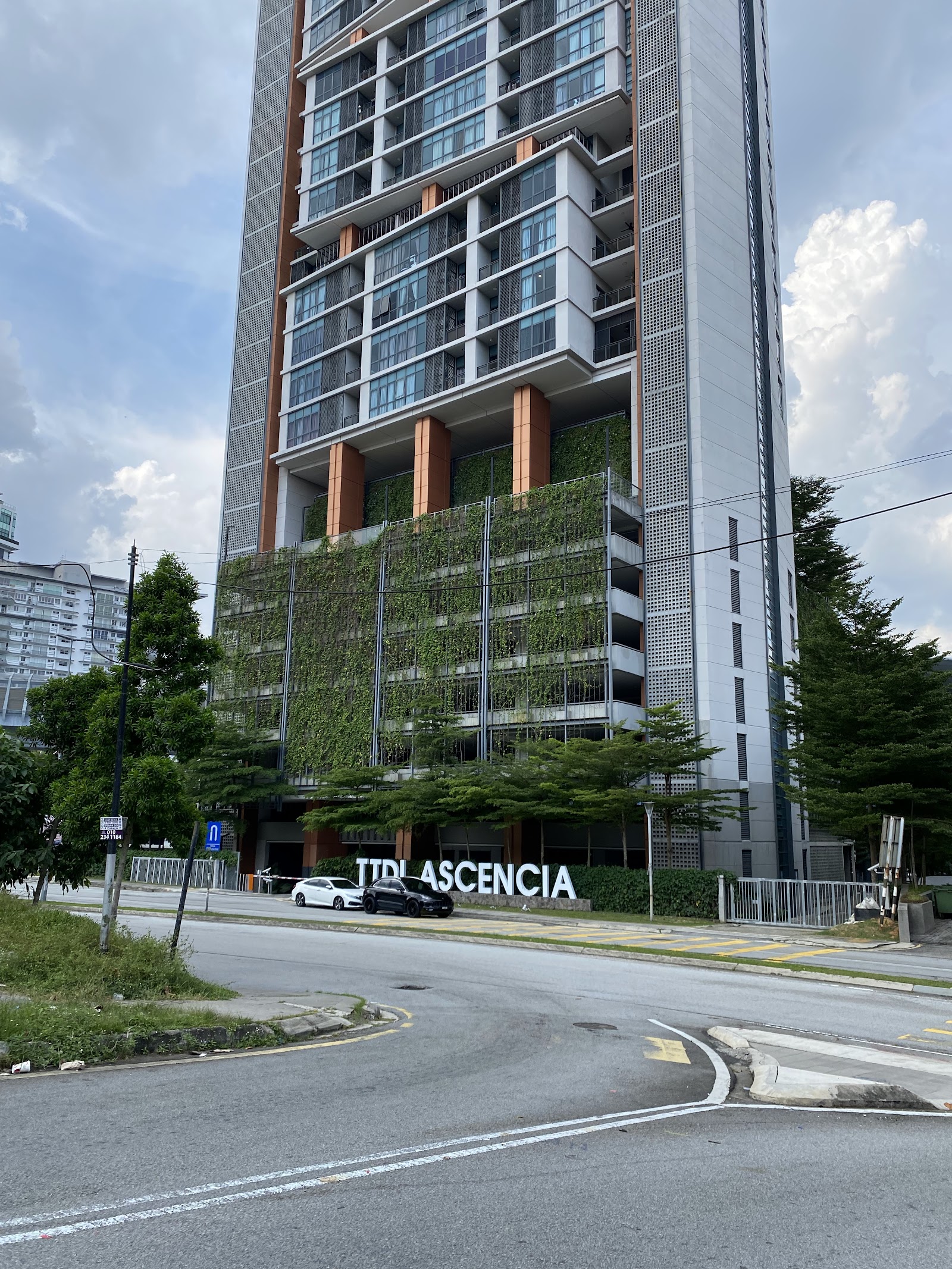 TTDI Ascencia: Street view of the TTDI Ascencia high-rise building with green vertical garden facade and signage at ground level
