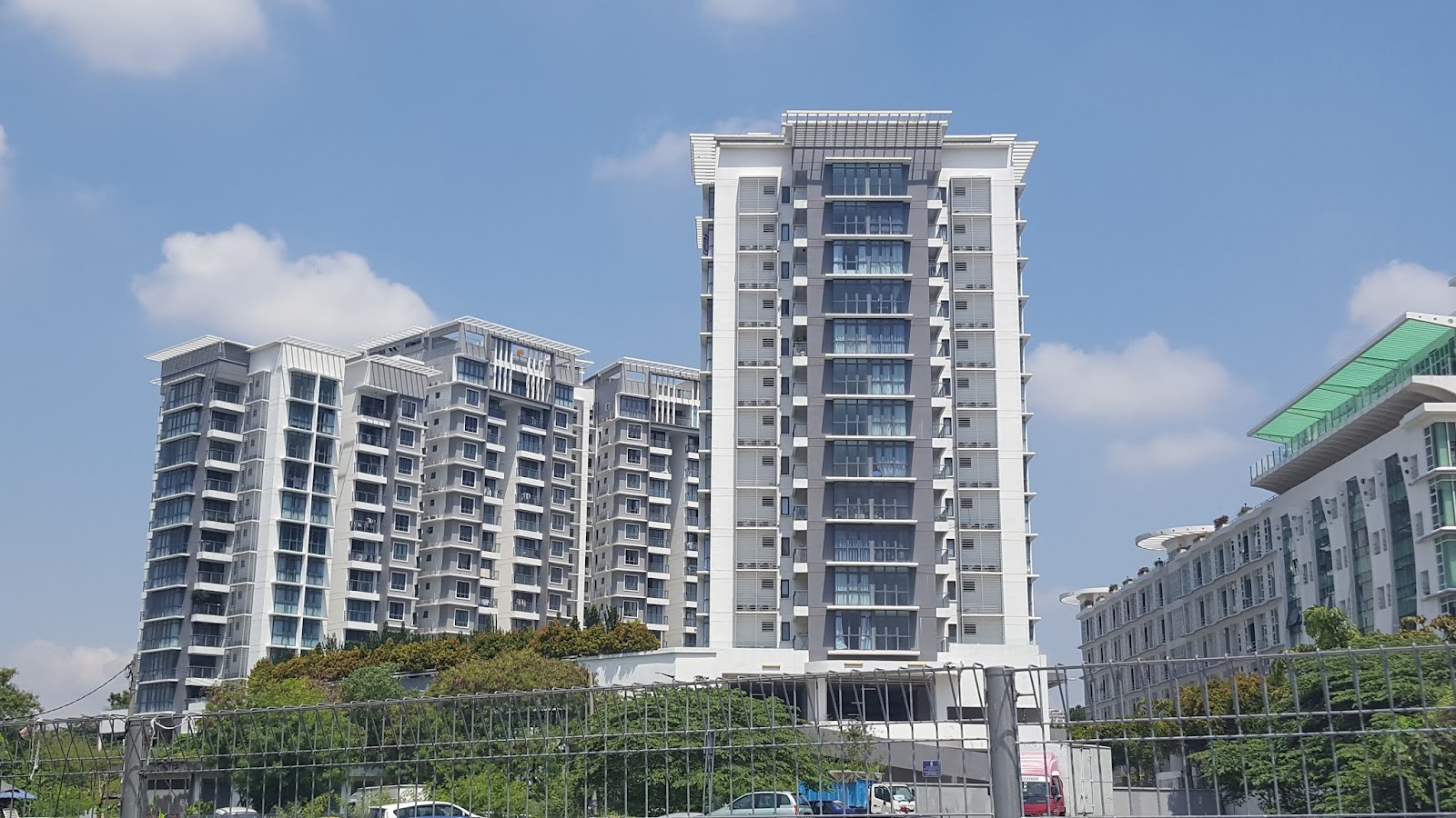 Boulevard Residence: High-rise residential towers viewed from outside, with trees and a fence in the foreground