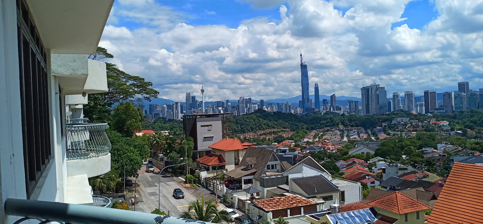 Casa Vista: City skyline view from a residential balcony, showing Kuala Lumpur towers including KL Tower and Merdeka 118, with suburban rooftops in the foreground