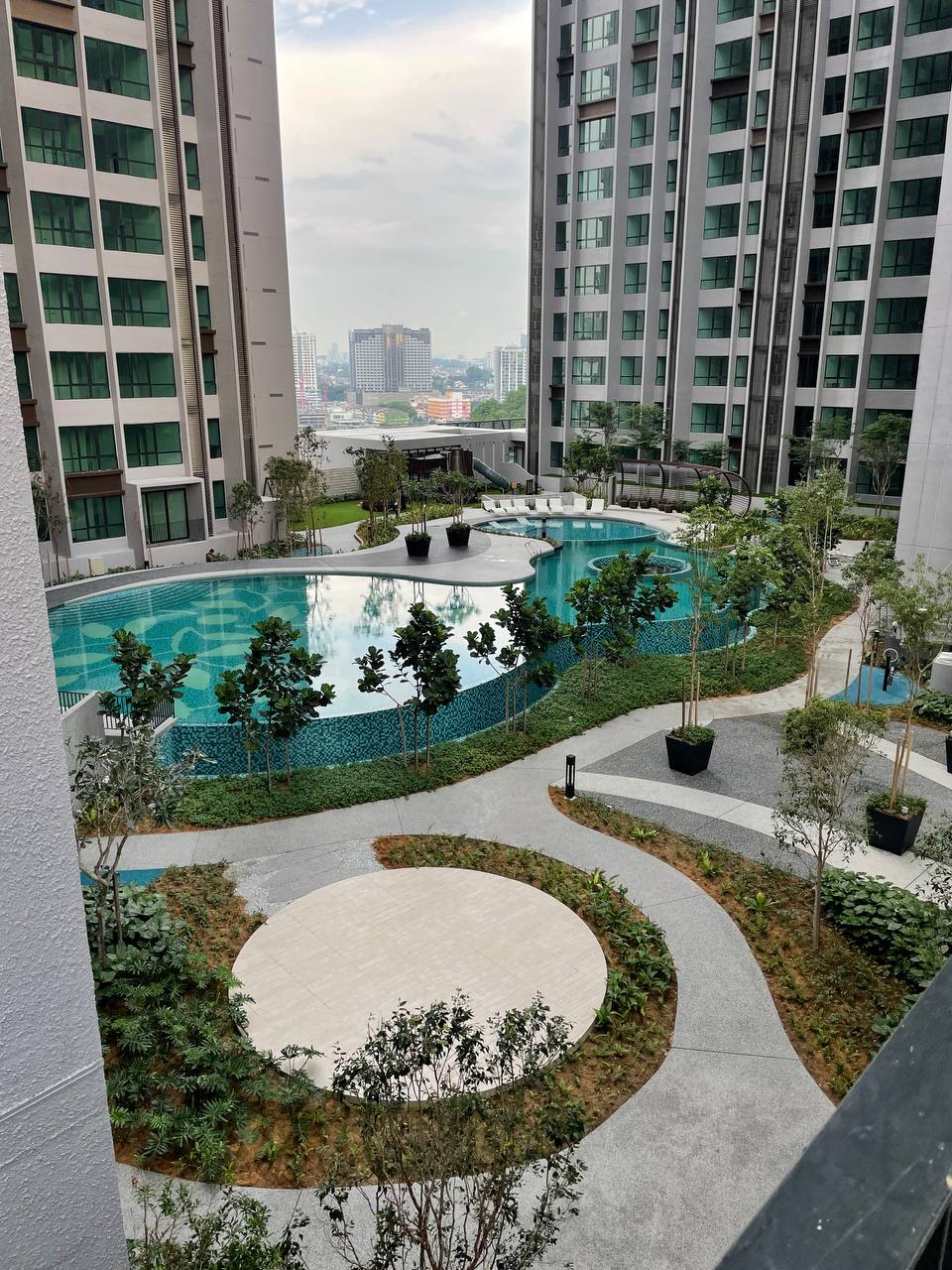 Cubic Botanical: Aerial view of a resort-style swimming pool and landscaped garden courtyard within a residential condominium development, surrounded by high-rise towers