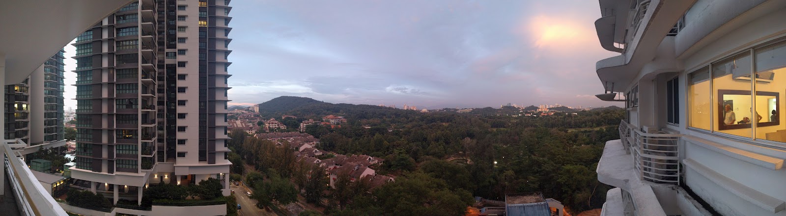 The Residence Condominium @ TTDI: Panoramic view from a high-rise balcony overlooking surrounding buildings, trees, hills and sky at dusk