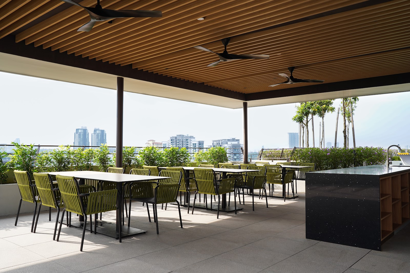 Utamara Boutique Residences: Rooftop dining terrace with tables and chairs under a wooden slatted ceiling, overlooking city skyline and greenery